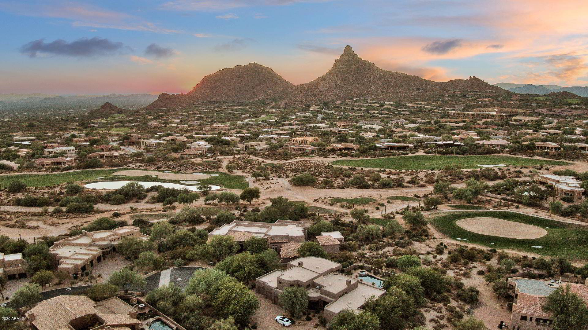 Aerial view of a golf course community in the Phoenix area with desert mountains in the distance