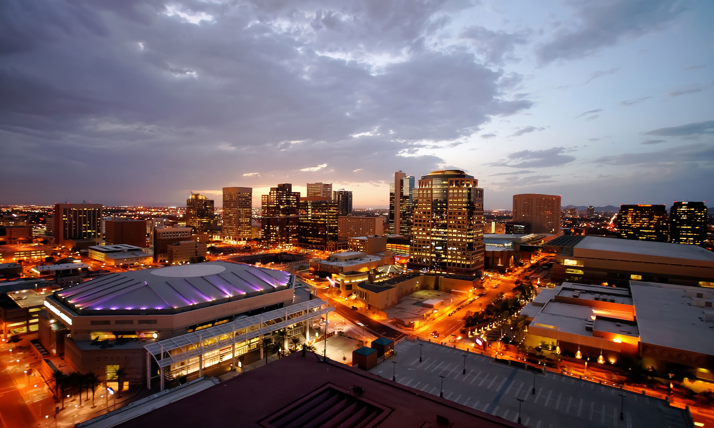 Downtown Phoenix skyline at dusk with city lights coming on